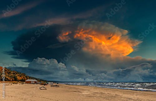 Colorful sunrise  and clouds above sandy beach of the Baltic Sea in Jurmala -...