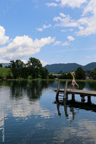 Summer, holidays. A girl swims in a lake in the mountains in Austria. Holidays in Austria