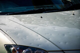 Car hood damaged by major hailstorm hailstones. Car insurance repair dents. Dented car bonnet