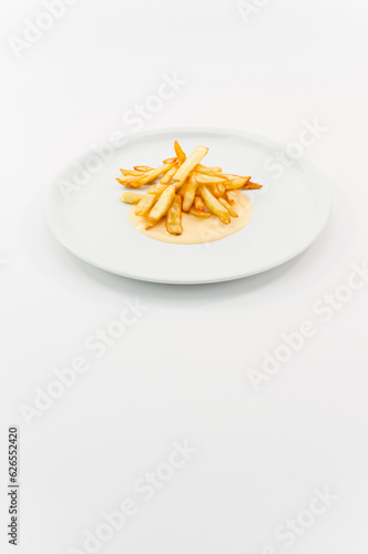 immagine primo piano di croccanti patatine fritte con salsa piccante su piatto in porcellana bianco su superficie bianca
 photo