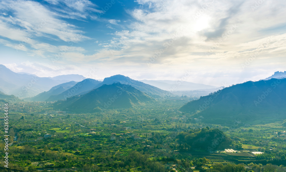 landscape of green summer highland mountain range with green beautiful valley below and amazing blue cloudy sky