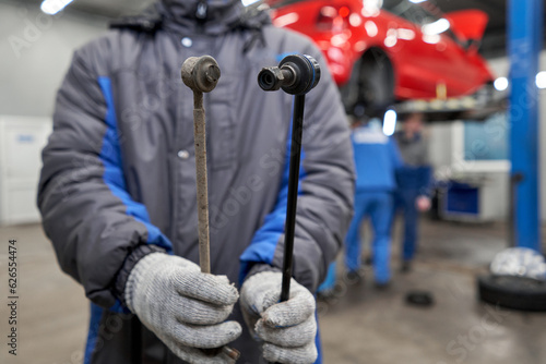 Fotografija New and old stabilizer bar or link arm ready to replacement into car suspension on metal table in garage for repair and maintenance
