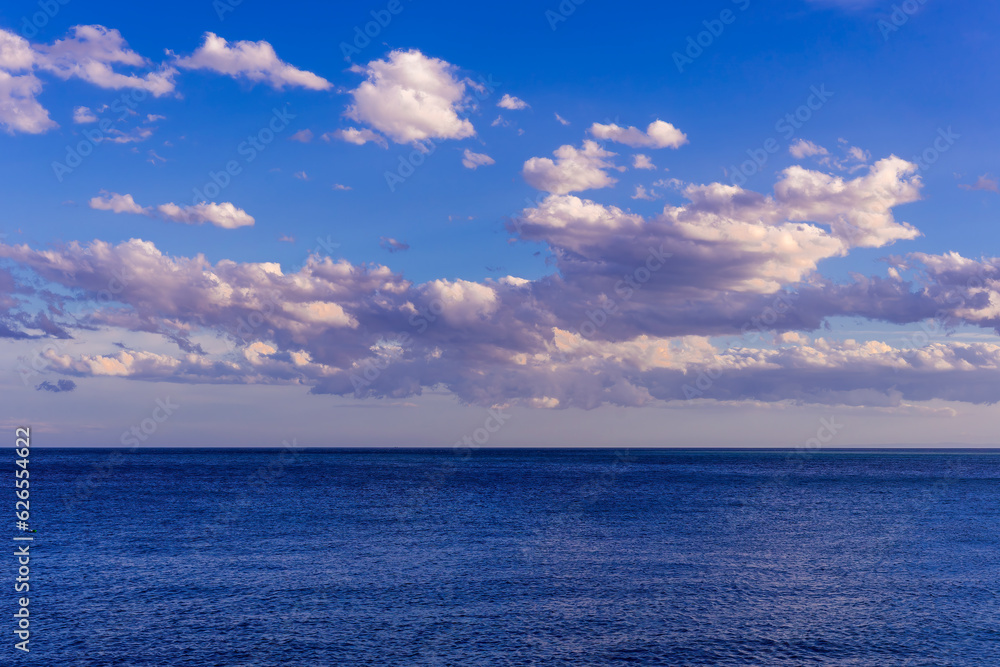 scenic blue seascape of sunset or sunrise above water with beautiful colorful evening clouds scenic blue seascape of sunset or sunrise above water with beautiful colorful evening clouds