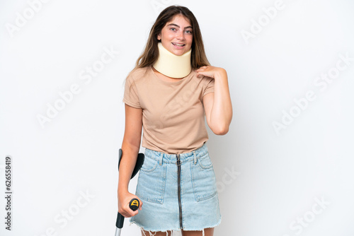 Fényképezés Young caucasian woman wearing neck brace and crutch isolated on white background