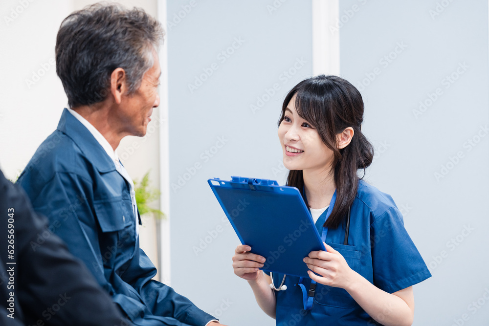 病院の受付で問診をする医療スタッフ 病院の受付で問診をする医療スタッフ