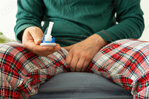 Urology, problems with urination in men. Health concept, A man in pajamas holds a catheter in his hand to help with peeing