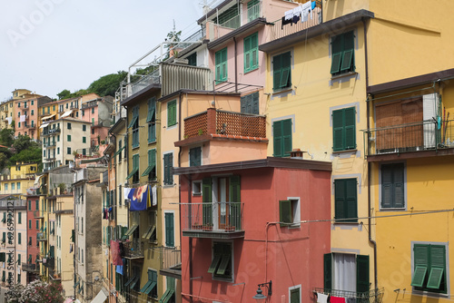 Cinque Terre, Italy - view of colorful houses with green windows in Riomaggiore, a seaside town on the Italian Riviera. Summer travel vacation background. Postcard from Europe. Architecture exterior.