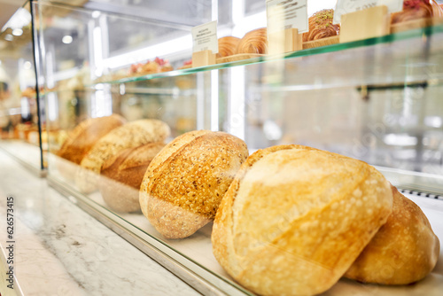 Different kinds of bread on the counter in the bakery shop. Fresh bread counter. Modern bakery with different kinds of bread, cakes and buns 