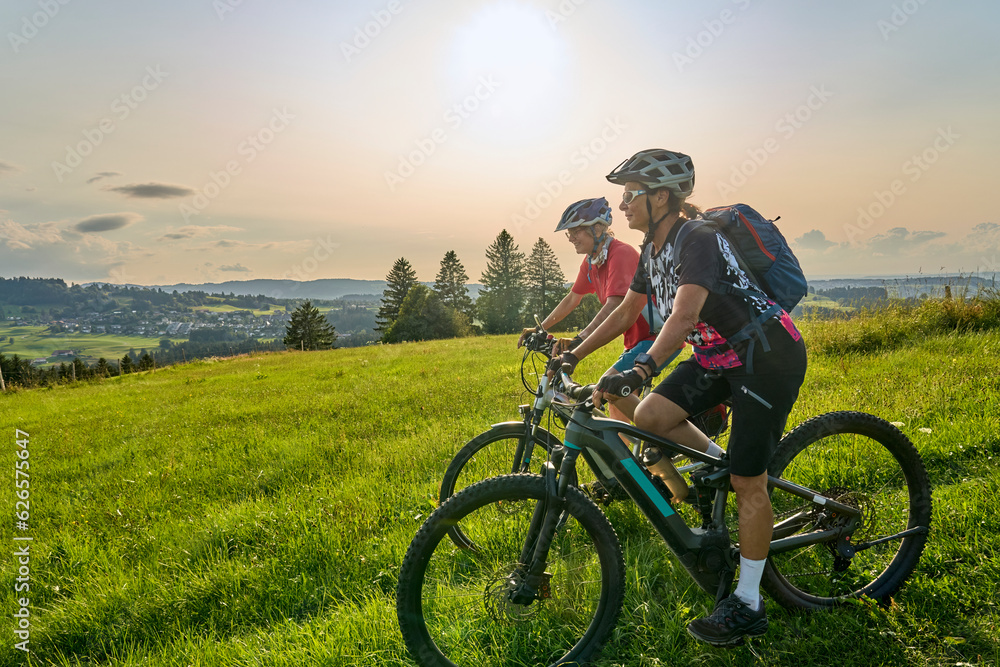 Obraz premium two senior girlfriends having fun during a cycling tour in the Allgau Alps near Oberstaufen, Bavaria, Germany