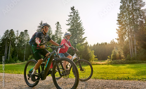 two senior girlfriends having fun during a cycling tour in the Allgau Alps near Oberstaufen, Bavaria, Germany photo