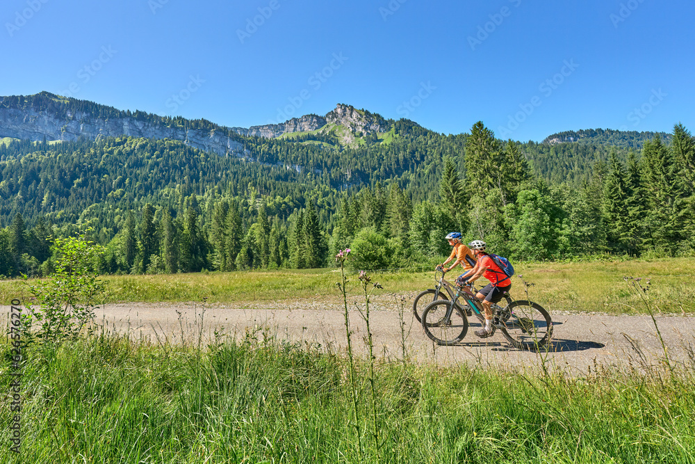 two senior girl friends having fun during a cycling tour in the Bregenz Forest near Sibratsgfäll, Vorarlberg, Austria