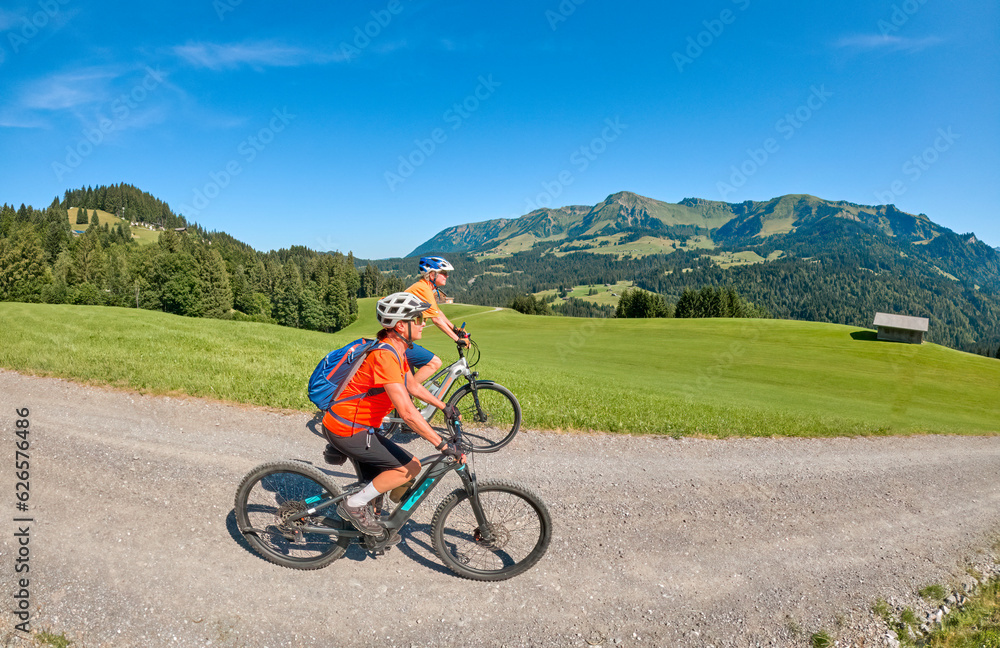 two senior girl friends having fun during a cycling tour in the Bregenz Forest near Sibratsgfäll, Vorarlberg, Austria two senior girl friends having fun during a cycling tour in the Bregenz Forest near Sibratsgfäll, Vorarlberg, Austria