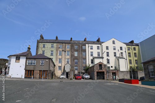 A row of old, tall and traditional terraced houses beside the harbour in Caernarfon, Wales, UK.