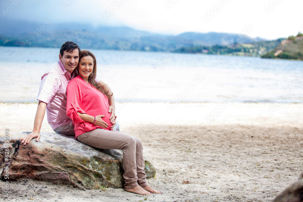 Young couple waiting for their baby at the beautiful white beach of Lake Tota located in the department of Boyaca at 3,015 meters above sea level in Colombia