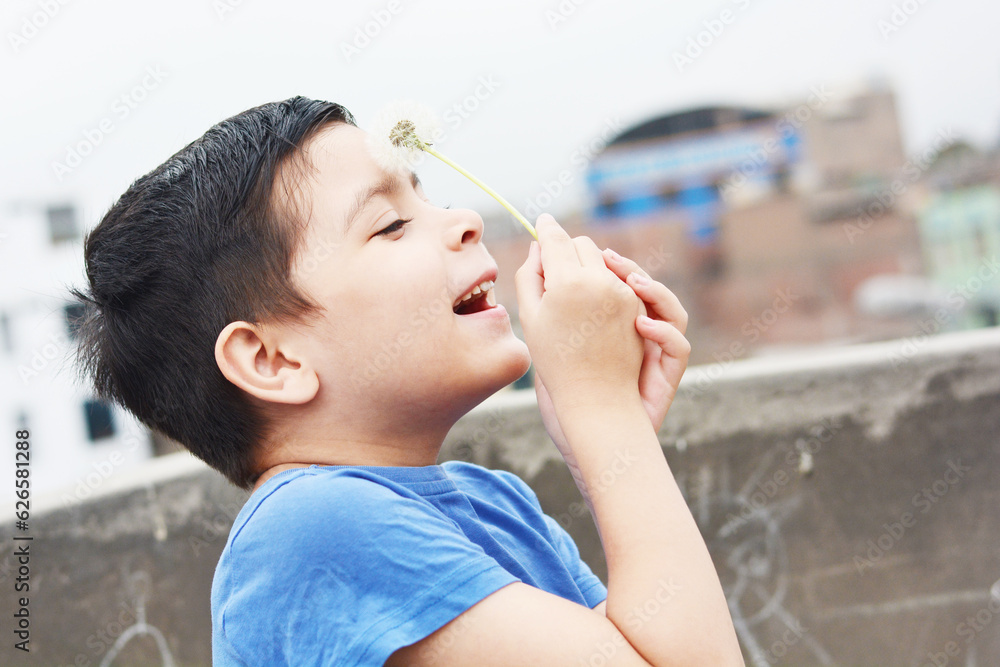 Obraz premium Little latin boy playing with a dandelion.