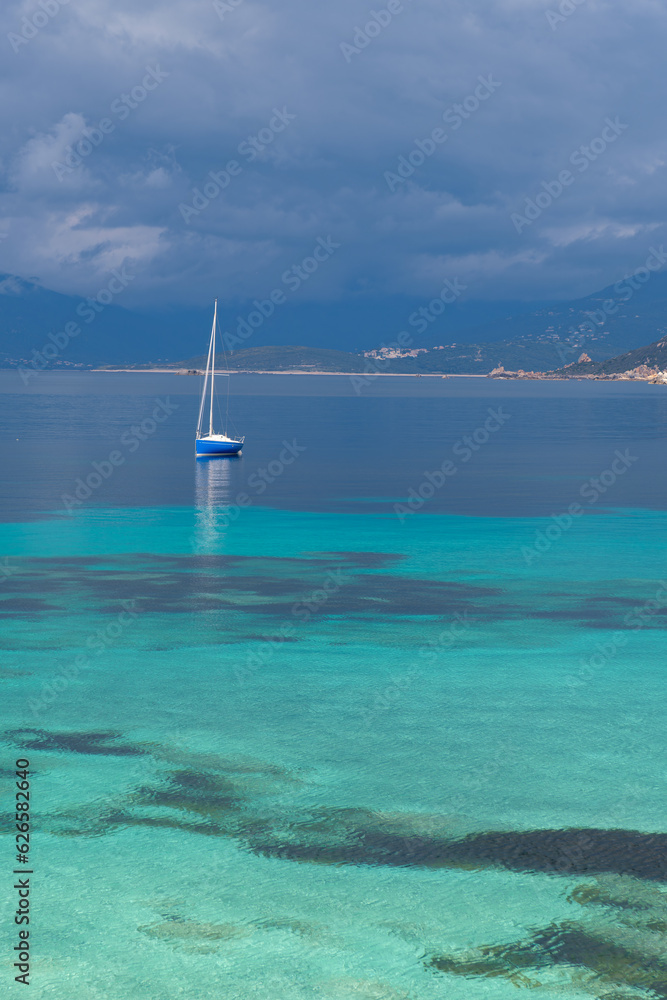 Bateau sur la mer en Corse du sud, eau turquoise et nuages menaçants