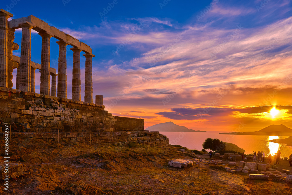 Sunset sky and ancient ruins of temple of Poseidon, Sounion, Greece