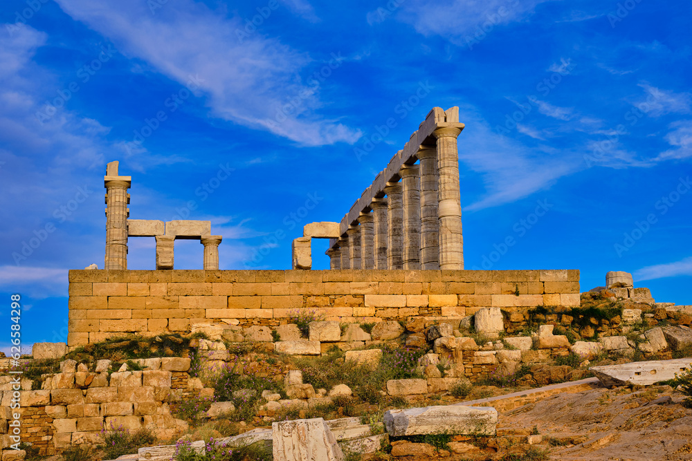 Sunset sky and ancient ruins of temple of Poseidon, Sounion, Greece