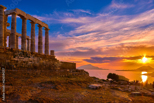 Sunset sky and ancient ruins of temple of Poseidon, Sounion, Greece