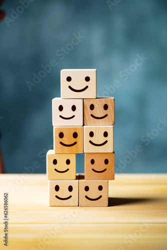 Stack of wooden blocks with faces drawn on them sitting on table.