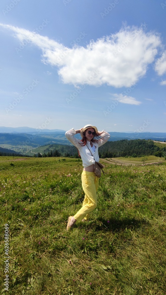 Traveling in summer Ukraine. Trip to Carpathian mountains. Woman tourist relaxing in flowers admiring view Traveling in summer Ukraine. Trip to Carpathian mountains. Woman tourist relaxing in flowers admiring view