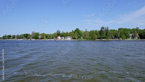 View from the fishing boat of typical summer cottages along Pike Bay at lake Huron, Ontario, Canada. Cottages for seasonal vacation rent and personal leisure. Tourist destination. photo
