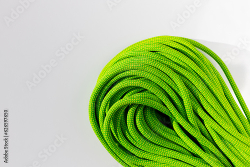 green rope for rock climbing and mountaineering lies on a white background. background image of rope for active sports.