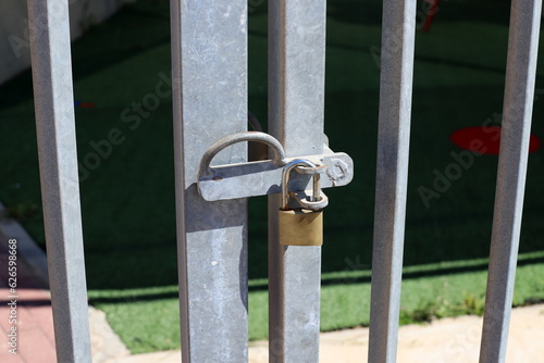 An old padlock hangs on the gate. © shimon