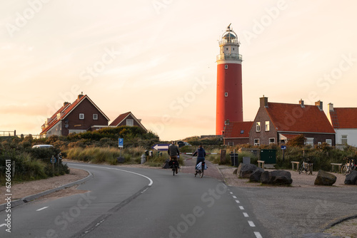 Two cyclists ride past the lighthouse on the Dutch island of Texel.