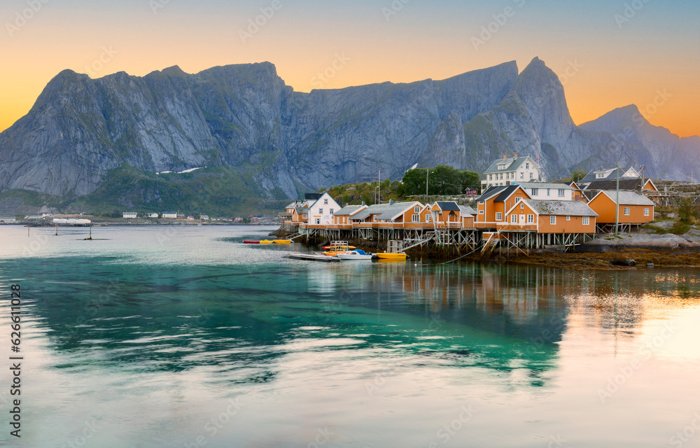 Naklejka premium Beautiful view of scenic Lofoten Islands archipelago winter scenery with traditional yellow fisherman Rorbuer cabins in the historic village of Sakrisoy at sunrise, Norway, Scandinavia