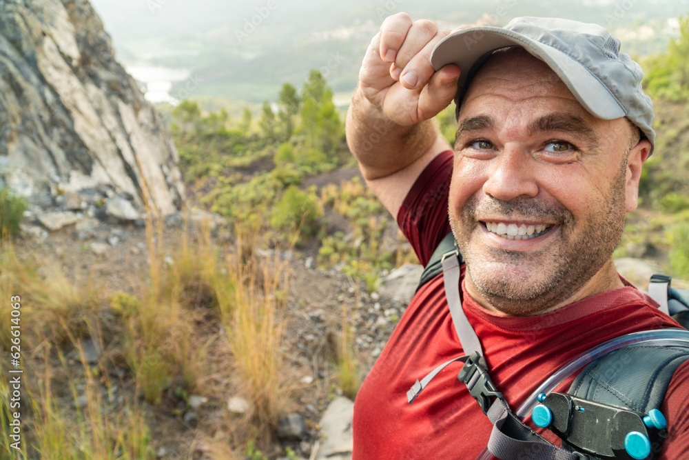 Smiling happy hiker takes a selfie outdoors.