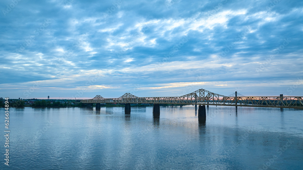 Indiana side Louisville KY aerial Ohio River bridges over water under blue and yellow clouds