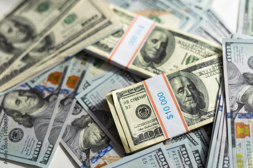 One hundred dollars pile as background. Many American dollars are slowly falling onto the table. Man throws green american money. American financial system. One hundred dollars pile as background. Many American dollars are slowly falling onto the table. Man throws green american money. American financial system.