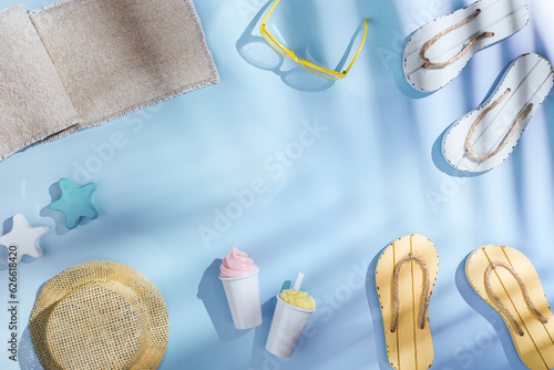 Summer flat lay pattern with beach accessories, Summer holiday or vacation concept, sunlight palm leaf shadow, aesthetic minimal style photo. Pastel blue colored background, above view, nautical