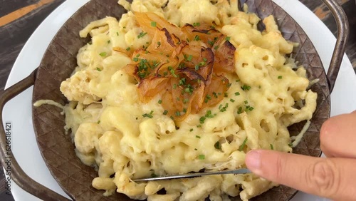 Eating Swabian noodles with cheese and onions, popular cheese spatzle photo