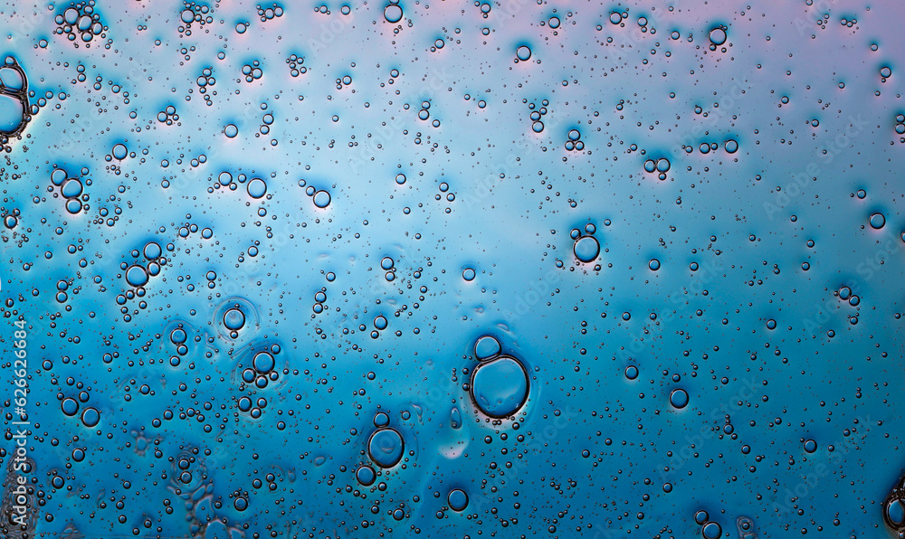 small air bubbles in water, with bright reflection on the light blue background
