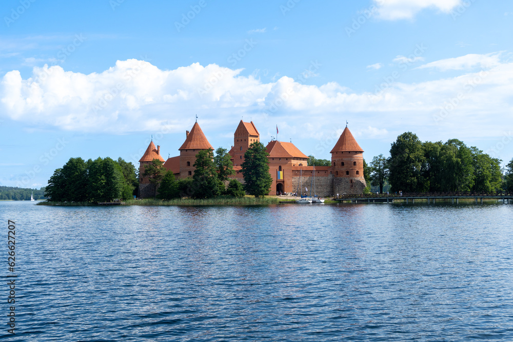 Naklejka premium Trakai Castle in the middle of the lake, on a sunny summer day with some clouds.