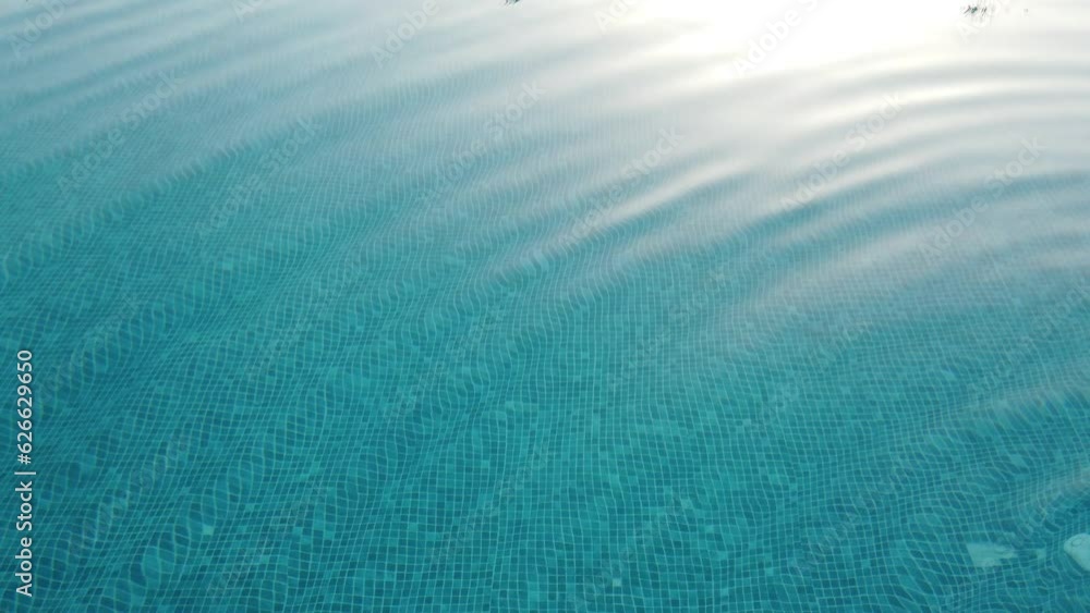 Pure blue water in the swimming pool with light reflections. Top view ...