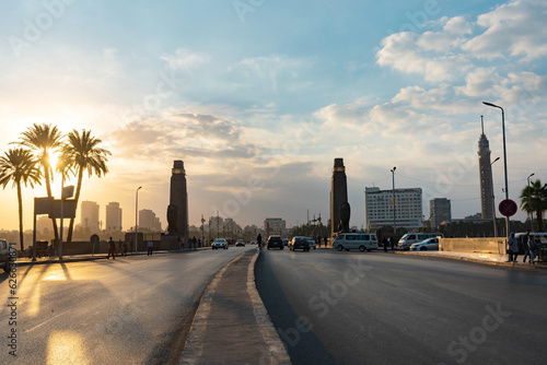 Qasr El Nil Bridge over the River Nile near Tahrih Square in Downtown Cairo cityscape at sunset panorama urban landscape .