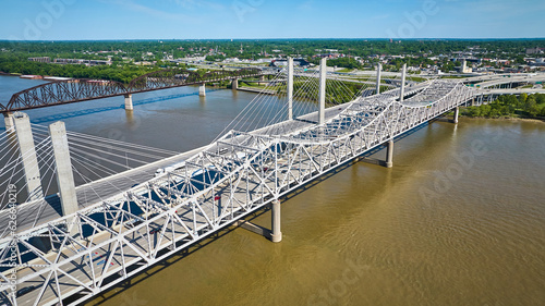Concrete and iron suspension and truss bridges over dirty water of Ohio River aerial