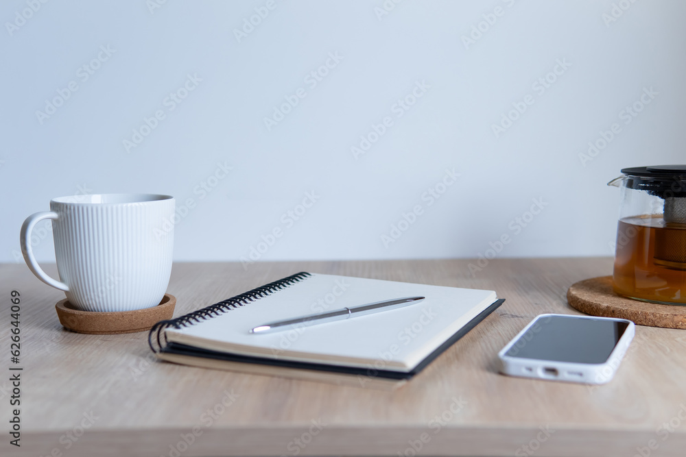 wooden table with notepad and cup of tea wooden table with notepad and cup of tea