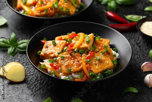 Homemade Stir Fry Tofu with Vegetables and Rice in black bowl.