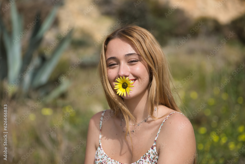Portrait of young woman, blonde and beautiful, very smiling and happy with a yellow daisy in her mouth. Spring concept, flowers, nature. Portrait of young woman, blonde and beautiful, very smiling and happy with a yellow daisy in her mouth. Spring concept, flowers, nature.
