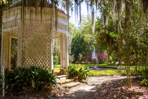 Beautiful gazebo with a fountain nestled in a beautiful flowering garden.