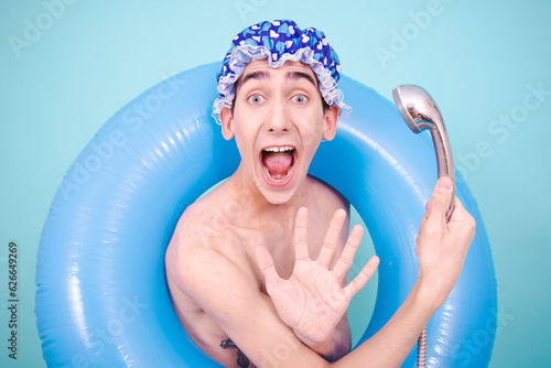 A man with different emotions washes in the shower in a blue cap.