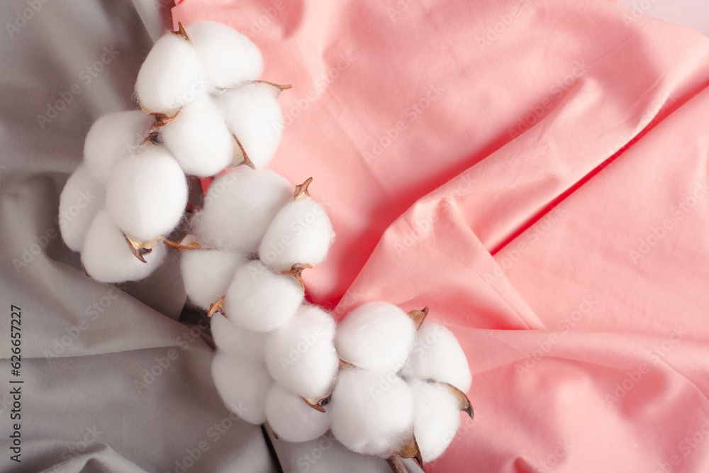 Cotton branch on green and pink crumpled fabric Cotton branch on green and pink crumpled fabric