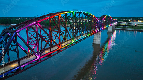 Obraz na płótnie Arch bridge aerial rainbow pride illuminated at night with reflected colors in w
