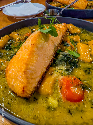 Oven-baked salmon fillet, served with sweet potato gnocchi in garlic sauce, white wine, butter, sage, roasted cherry tomatoes, spinach and parmesan.
