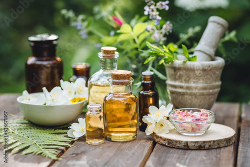 Concept of pure natural ingredients in cosmetology, aromatherapy, naturopathic, herbal extracts and essence. Assortment of glass bottles with organic essential aroma oil with mint, wooden background