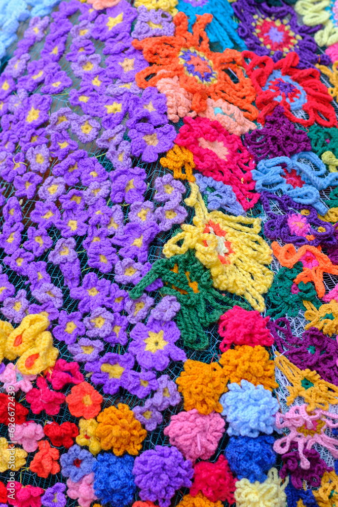 Beautiful colourful wool textile handmade flowers in a textured background still